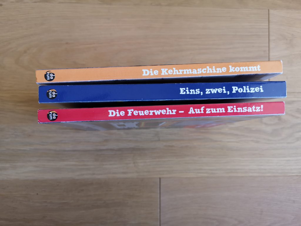 Drei Buchrücken aus dem Darum Verlag - die Kehrmaschine, die Polizei, die Feuerwehr